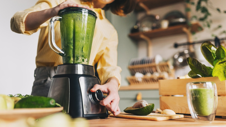 Woman blending a green smoothie