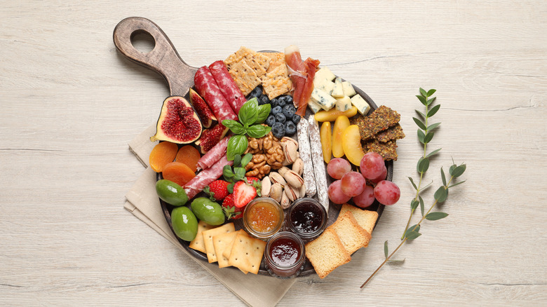 Colorful snack plate with garnishes on wooden board