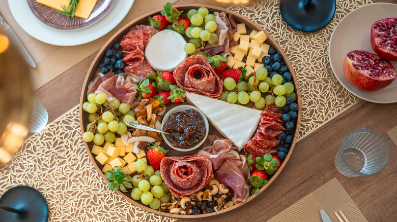 Snack plate with cheese, meat, and fruit on table