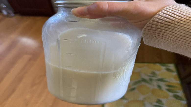 Hand shaking milk in Mason jar