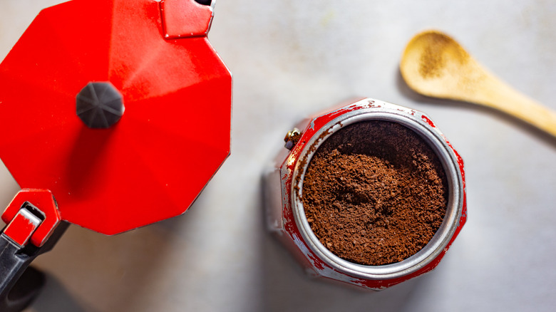 Red Moka pot filled with coffee grounds