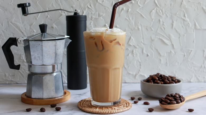 Moka pot, manual grinder, iced coffee drink, and coffee beans
