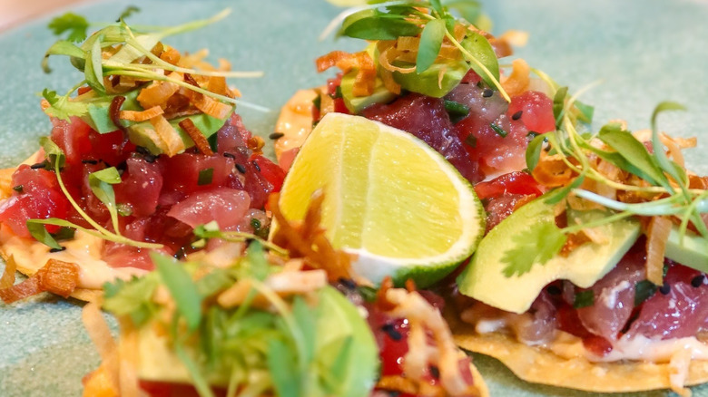 Plated ahi toast with lemon wedge and green garnish
