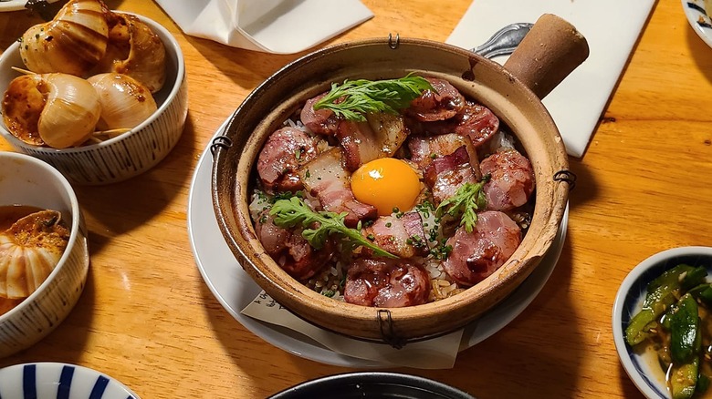 Claypot rice dish with egg yolk on a dining table