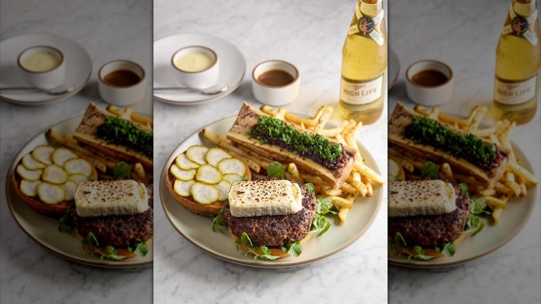 Open face burger, fries, and beer on table