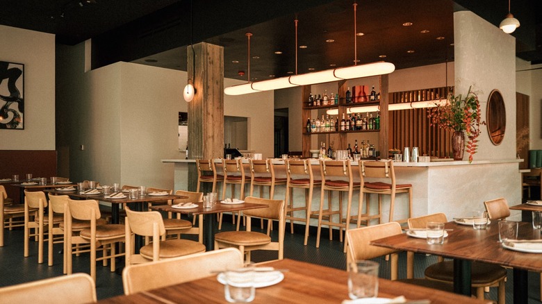 The Happy Crane interior with wooden chair and tables and small bar section