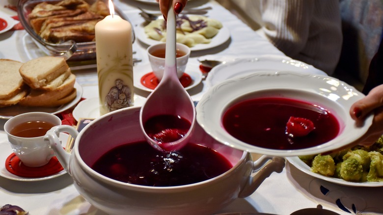 Person ladling barszcz with uszka into a bowl