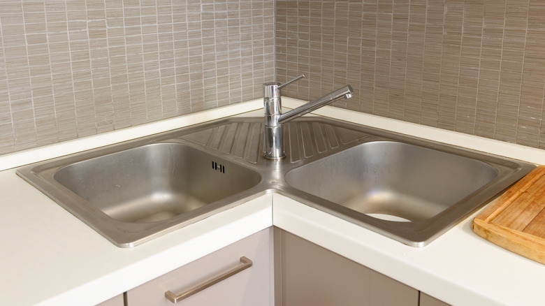Detail shot of a stainless steel corner sink in a kitchen