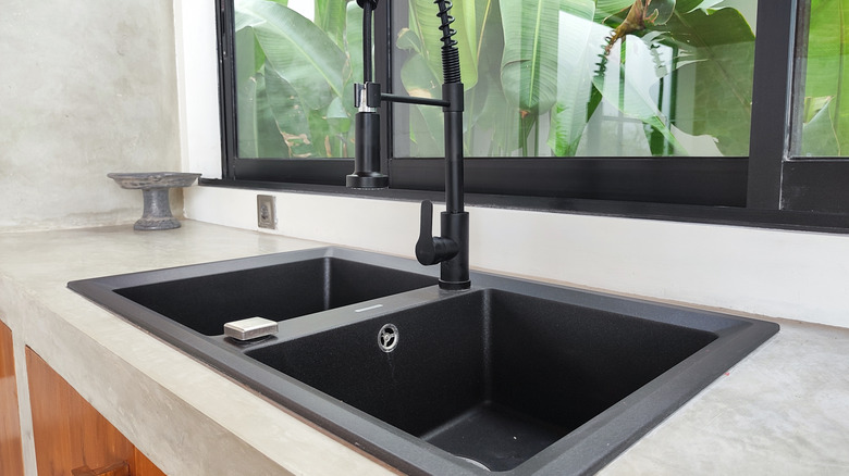 Double bowl kitchen sink surrounded by empty countertops