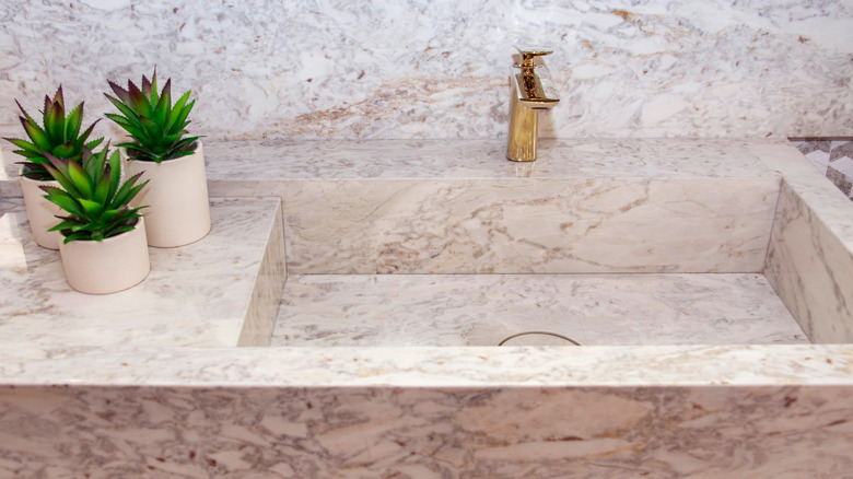 View of integrated kitchen sink, countertops and backsplash carved from marble