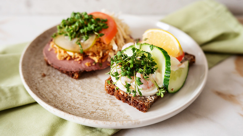 Traditional Danish open-faced sandwich on plate, topped with microgreens