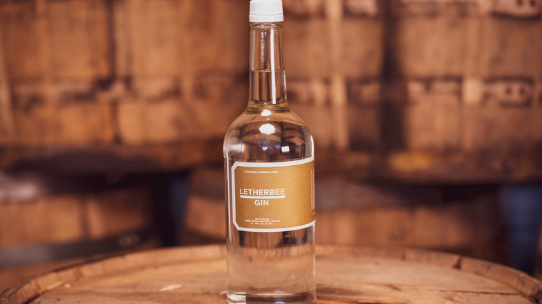 A bottle of Letherbee Gin centerstage on a barrel.