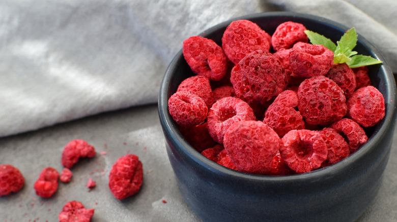 Bowl of freeze dried raspberries with some spilling out