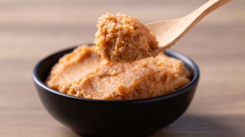Spooning yellow miso paste from black bowl