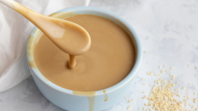 Spooning tahini from bowl