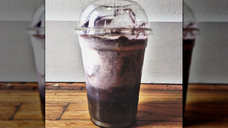 Grape soda float in plastic cup with straw