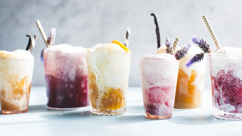 Various flavors of ice cream floats in glasses