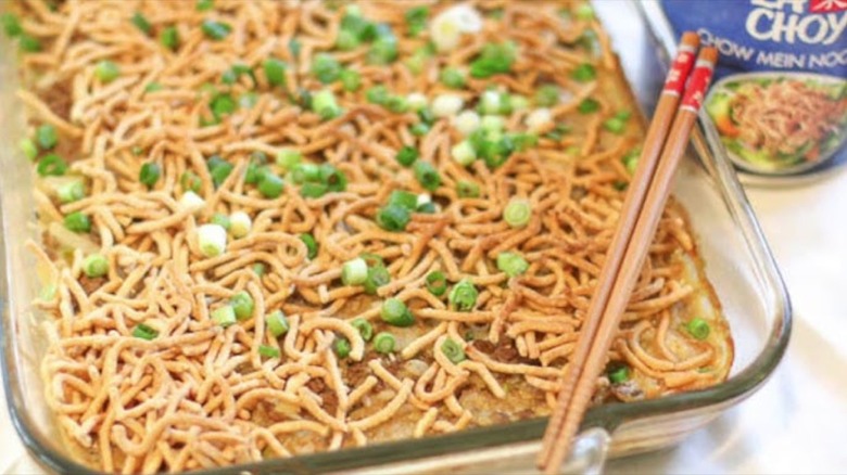 Clear dish with chow mein casserole and chopsticks on top