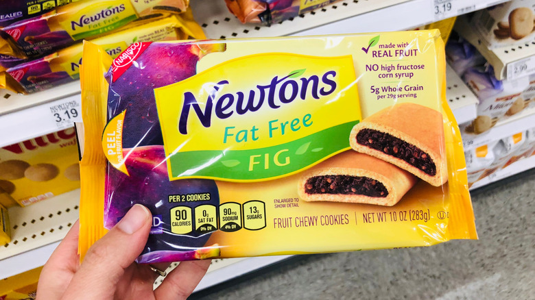 A person holds a pack of fat free Fig Newtons.