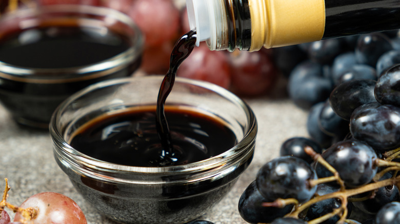 Pouring balsamic vinegar from bottle into bowl