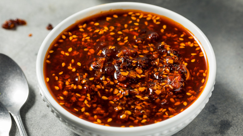 Chili crisp in a white bowl on a grey table