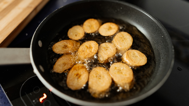 Plantains frying in a black pan
