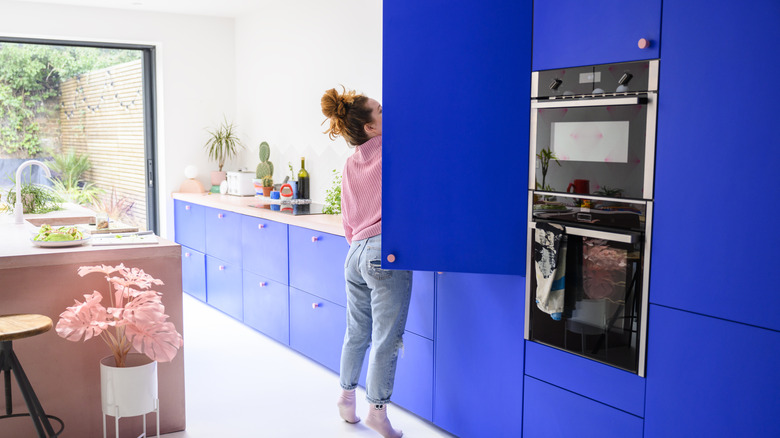 Kitchen with bright blue cabinets and pink island