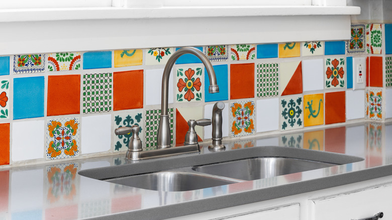 Close-up of a backsplash with red, blue, yellow, and patterned tiles