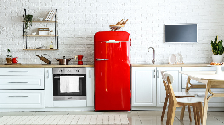Modern white kitchen with a retro red fridge in the center
