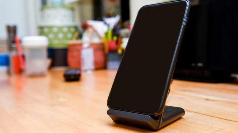 Mobile cell phone charging on wireless charger in home interior.