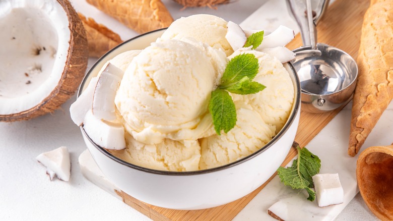 Scoops of coconut ice cream in bowl with fresh mint garnish