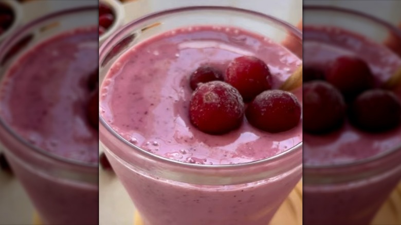 Close up of cranberry smoothie in glass, topped with fresh cranberries