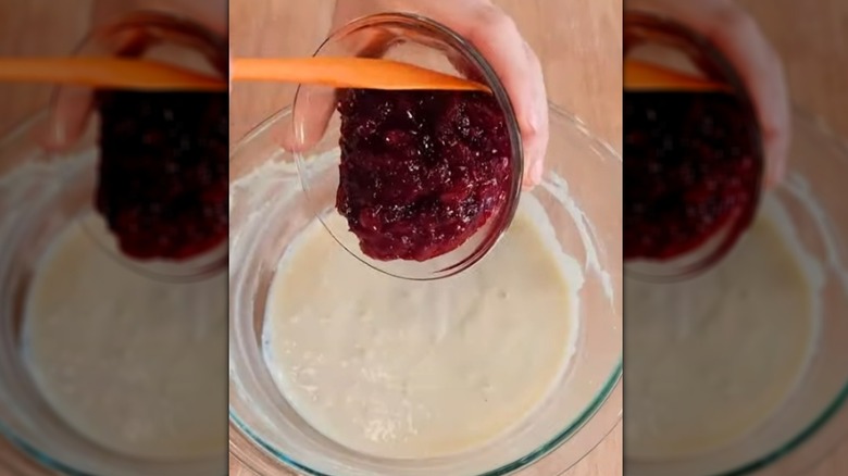 Scooping cranberry sauce into bowl of pancake batter