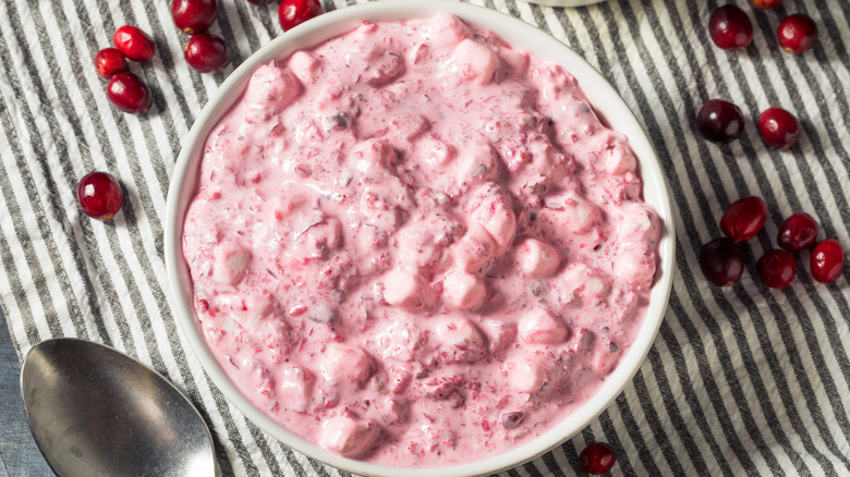 Bowl of cranberry fluff surrounded by fresh cranberries