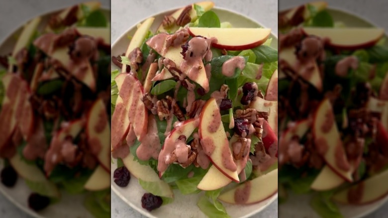 Plate of apple and walnut salad topped with cranberry dressing