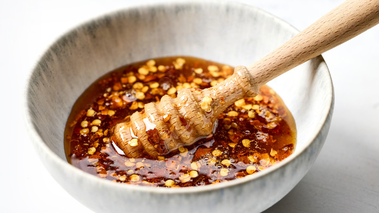 A bowl of hot honey with a honey dipper in it