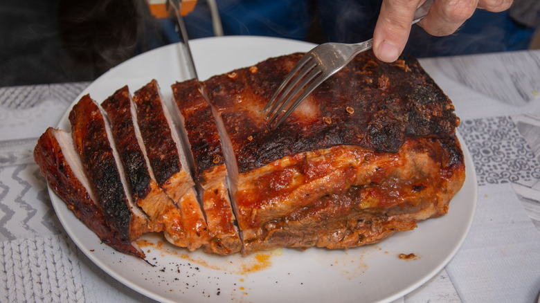 A honey glazed pork roast being cut into slices