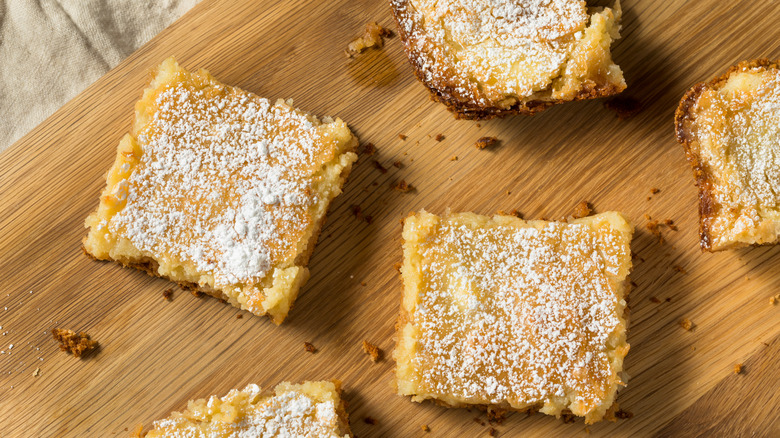 Squares of gooey butter cake on a wooden board