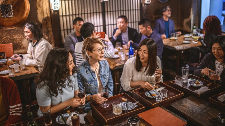 People sitting around a hibachi grill enjoying each others company