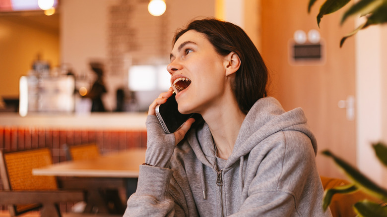 Woman talking on smartphone at restaurant