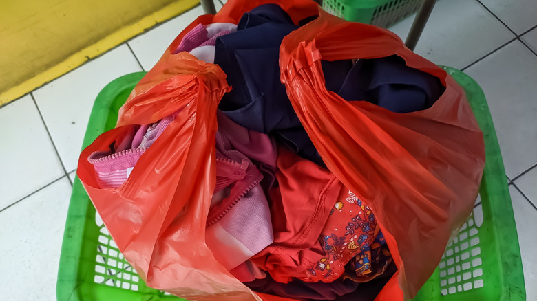 Dirty laundry in red plastic grocery bag