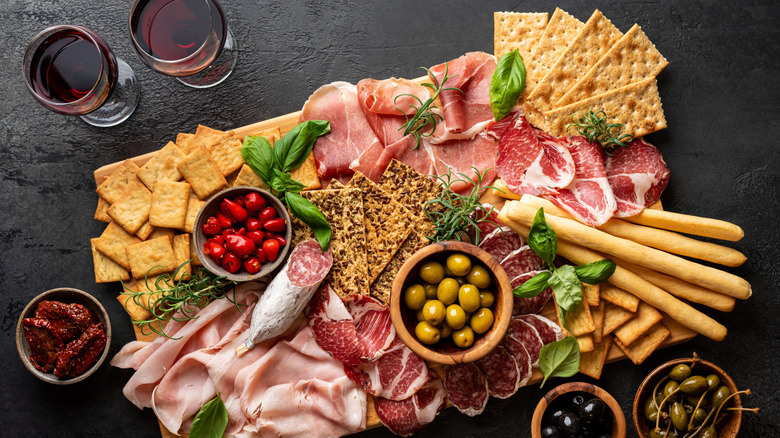 charcuterie board with two red wine glasses