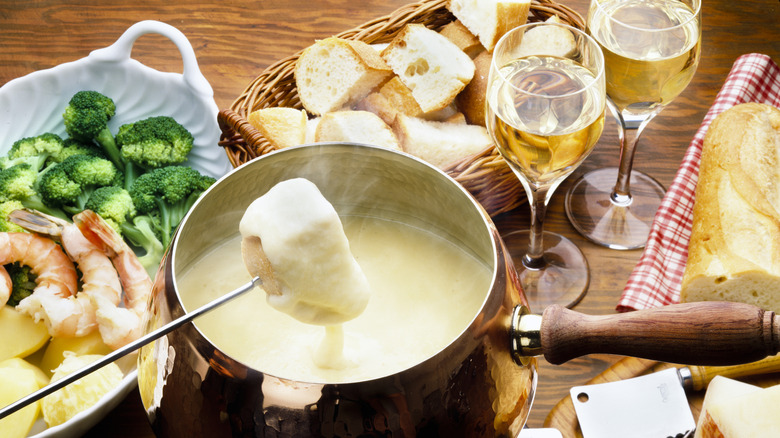 cheese fondue with two glasses of white wine
