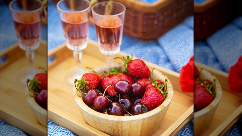 two glasses of rosé wine with bowl of berries