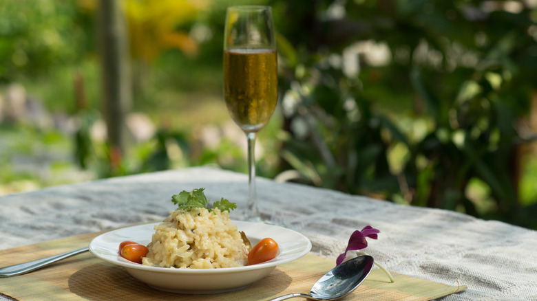 plate of risotto with glass of sparkling wine