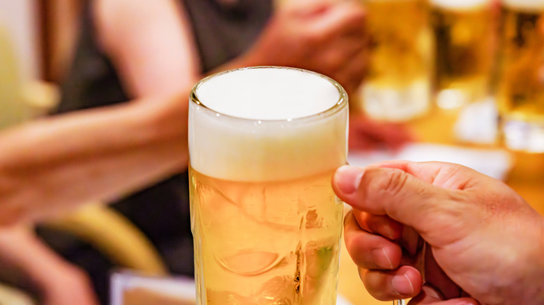 hand holding pint of beer with handle