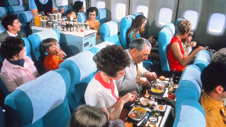 passengers eat food on an airplane