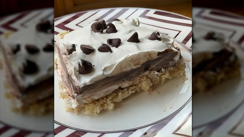 Slice of chocolate delight cake with whipped topping and chocolate chips