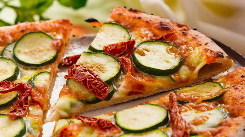 Pizza topped with zucchini slices and sundried tomatoes
