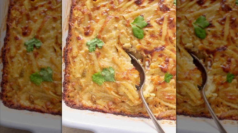 Delmonico potato casserole in a white dish, with a spoon